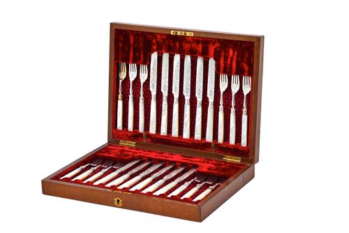 A late Victorian set of twelve silver pairs of dessert or fruit knives and forks, having silver blades and prongs with engraved decoration and with mo