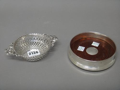 A silver twin handled bonbon dish of circular form, having pierced decoration and having cast handles, Birmingham 1913 and a silver mounted circular b