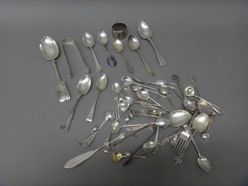 Mostly silver, comprising; thirty-one various spoons, a napkin ring, three pairs of sugar tongs, a butter knife and a fork, combined weight 665 gms, a