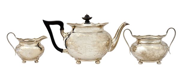 A silver three piece tea set, comprising; a teapot having black fittings, a twin handled sugar bowl and a milk jug, each piece of oval form having sha