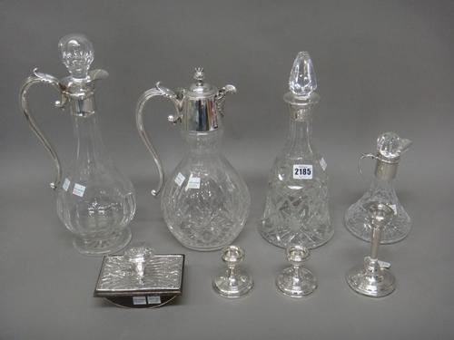 Silver mounted wares, comprising; a faceted glass bell shaped decanter, a small ship's style faceted glass decanter, a roller desk blotter, a pair of