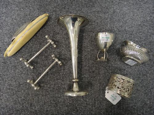 Silver and silver mounted wares, comprising; a pair of knife rests, Sheffield 1911, an egg cup, Sheffield 1909, a trumpet shaped vase, a nail buffer,
