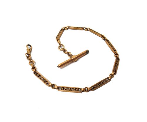 A French gold watch Albert chain, in a pierced bar and ridged circular link design, fitted with a gold swivel and with a gold cased base metal T bar/w