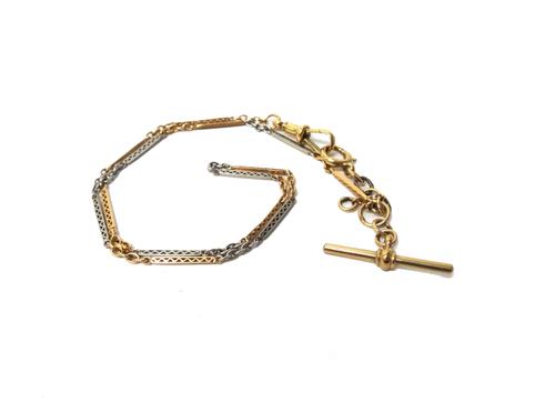 A two colour gold pierced bar and oval link watch Albert chain, fitted with a T bar detailed 375, a swivel detailed 18 C and with a bolt ring, gross w
