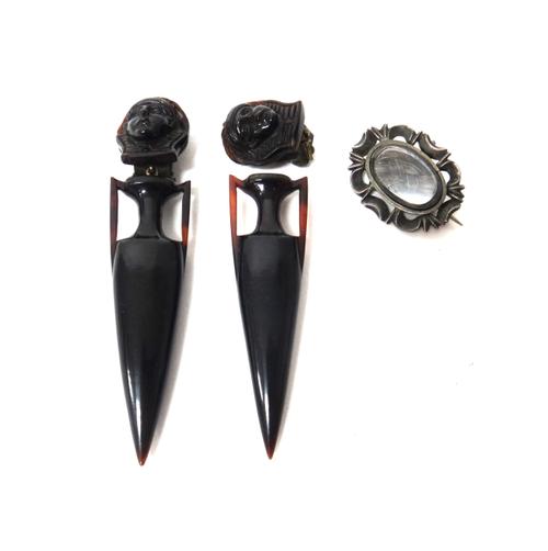 A pair of tortoiseshell earclips, each designed as an ancient Egyptian mask of a pharaoh above a twin handled tapering vase, the backs with later base