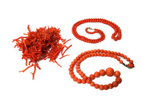 A single row necklace of graduated coral beads, on an oval base metal clasp, a single row necklace of graduated darker coral beads, on a boltring clas