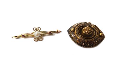 A Victorian oval brooch, with applied bead and wirework decoration, the back glazed with a locket compartment, circa 1870 and a gold, ruby and culture