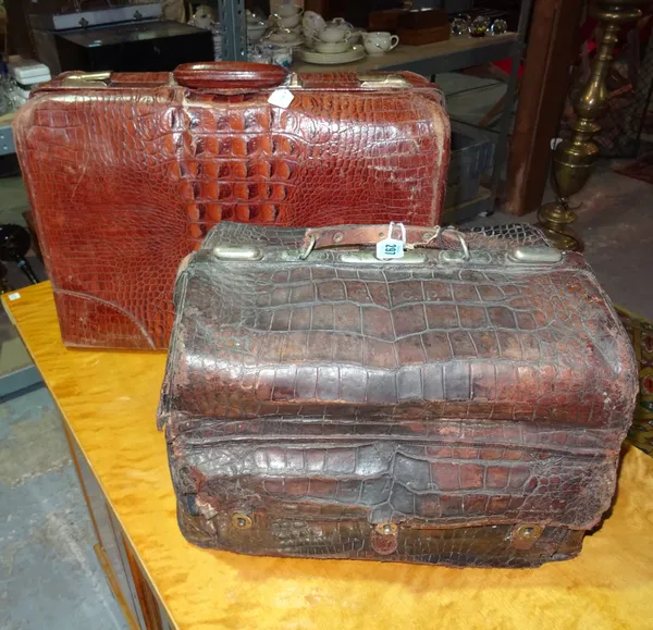 An early 20th century crocodile skin travelling vanity case and a similar suitcase, the largest 52cm x 35cm, (2).  H2