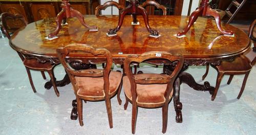 An Italian marquetry inlaid walnut dining table, the rounded rectangular top on six carved downswept supports, 119cm wide x 240cm long.  F9