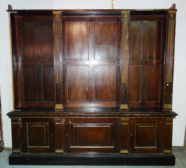 A late 19th century stained and gilded triple section bookcase cabinet of Regency design, the base with three panel cupboards on plinth, cornice lacki