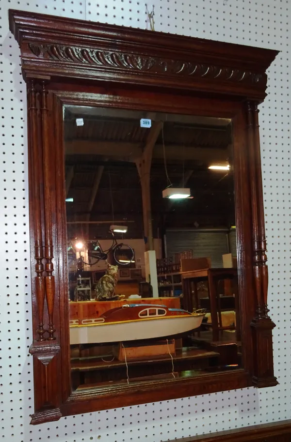 A 20th century oak framed oval wall mirror with spindle turned top rail, 84cm wide x 105cm high.   H10