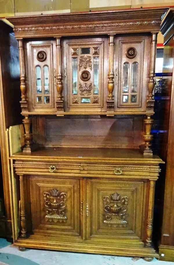 A 19th century oak dresser, with glazed top over two door cupboard base with urns and acanthus decoration flanked by fluted turned supports, on bun fe