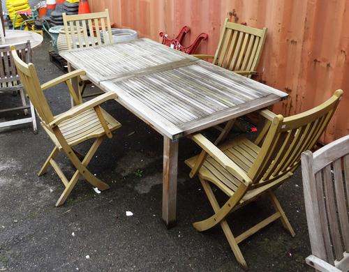 'Barlow Tyrie'; a 20th century hardwood extending rectangular garden table, 176cm wide x 73cm high and a set of four matching folding armchairs, (5)