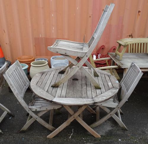 A 20th century hardwood circular folding garden table 109cm wide x 73cm high, together with three folding garden chairs, (4).  OUT