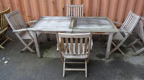 'Barlow Tyrie'; a 20th century hardwood extending rectangular garden table, 176cm wide x 73cm high and a set of four matching folding armchairs, (5)