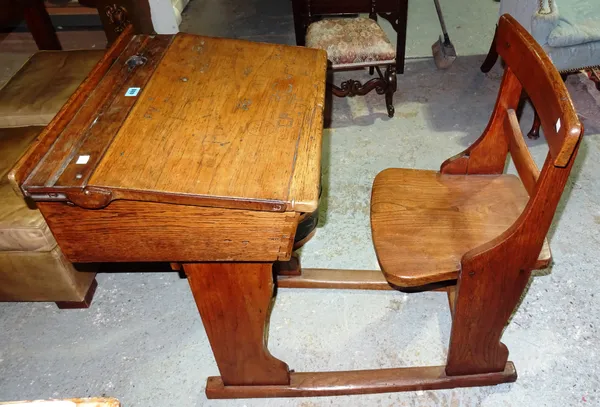An early 20th century oak school desk, with fitted bar back chair, 57cm wide x 80cm high.  K3