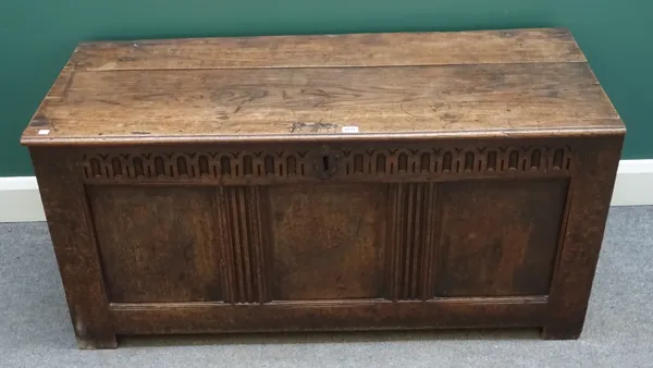 A 17th century and later oak coffer, the plank top over triple panel front, 122cm wide x 53cm deep x 58cm high.  J9