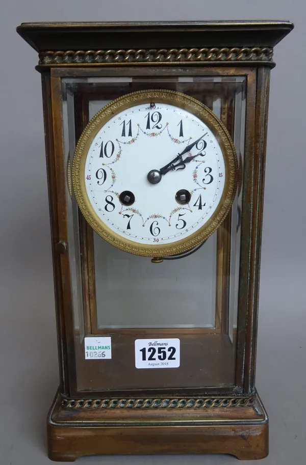 A French brass four glass mantel clock, early 20th century, with foliate painted enamel dial and two train movment with hammer striking a coiled gong,