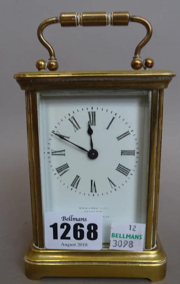 A late 19th century brass cased carriage clock, the white enamel dial detailed 'HAMILTON & CO CALCUTTA MADE IN FRANCE', presentation engraved 'S.T.C.