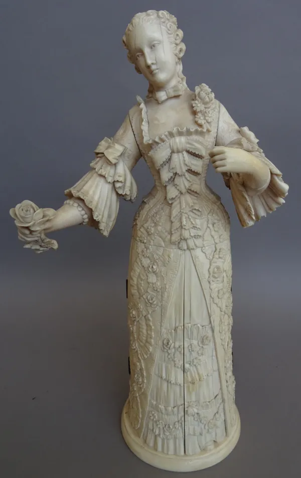 A Dieppe carved ivory figural triptych, 19th century, modelled as a lady wearing a ball gown, the lower half opening on hinged doors to reveal an inte