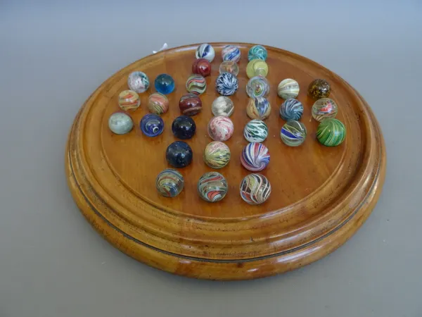 A Victorian fruitwood solitaire board of turned circular form containing 33 marbles. (29cm diameter)  Illustrated