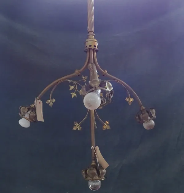 A set of three gilt metal four branch altar chandeliers, late 19th/ early 20th century, each on a long spiral twist hanging pole with foliate cast emb