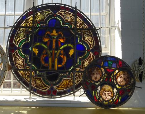 Seven stained leaded glass panels, 19th century, each of circular form depicting flora and fauna (102cm diameter) and one similar smaller panel (53cm