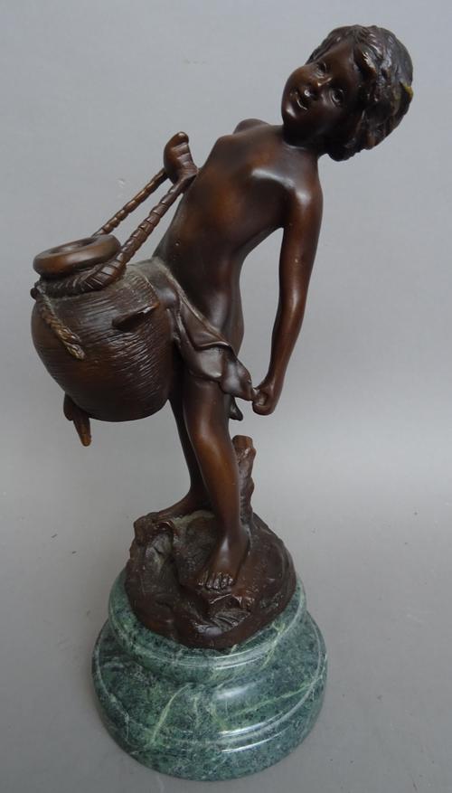 After Moreau, a French bronze figure of a young boy water carrier, on a naturalistic rocky base and green marble circular turned plinth, 36.5cm high o