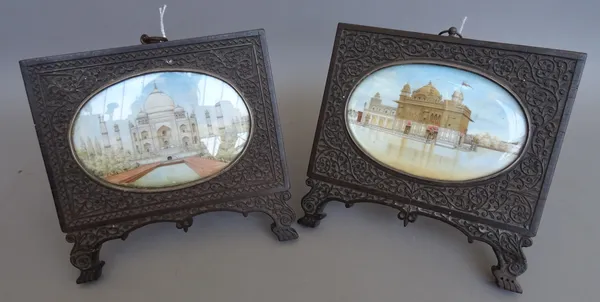 A pair of Indian miniature painted ivory plaques, 19th century, depicting The Taj Mahal and The Golden Temple, each oval mounted in a foliate carved h