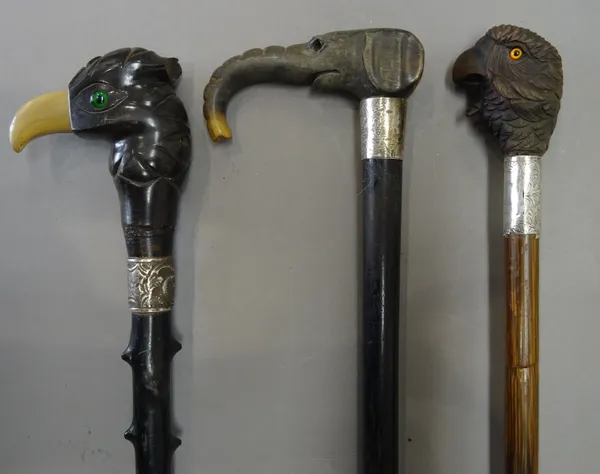 A horn and hardwood mounted 'parrot's head' walking stick, early 20th century, with black thorn ebonised shaft (90cm), a horn mounted 'elephant head'
