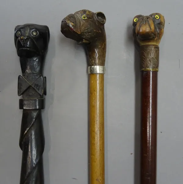 Two Victorian carved wooden 'dog's head' walking canes, each boxer dog with inset glass eyes (91cm) and one further 'dog's head' walking cane, 19th ce