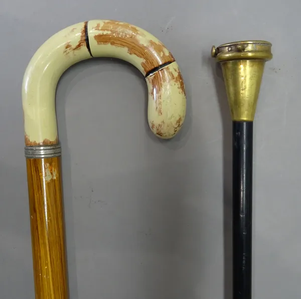 A brass mounted 'tape measure' gadget walking cane, early 20th century, on an ebonised cylindrical shaft (92cm) and one further gadget walking stick,