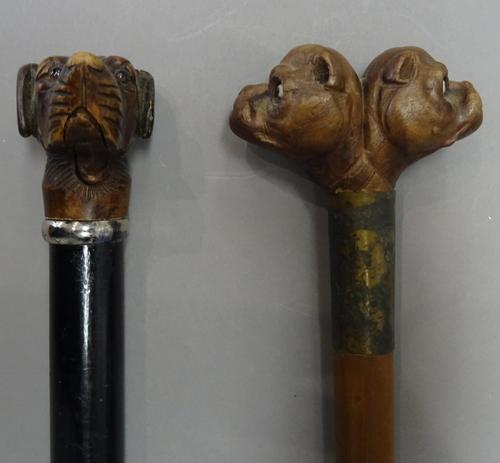 A Black Forest wooden 'dog's head' walking cane, early 20th century, the pommel carved with opposing bulldog heads over a silver mounted cylindrical s