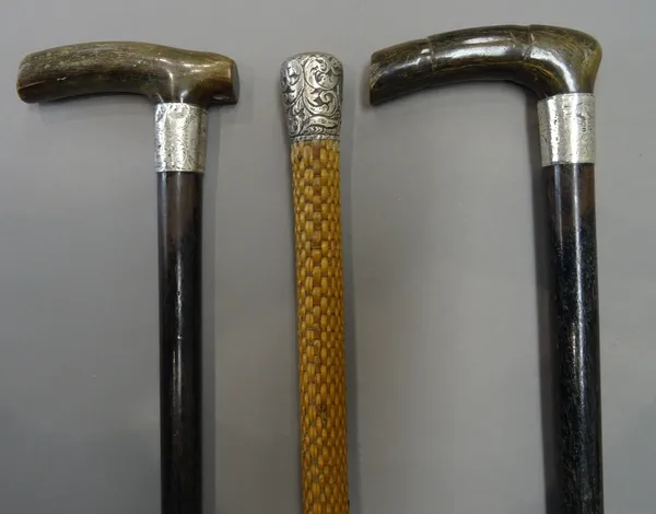 Two late Victorian horn mounted ebonised walking sticks, each with foliate engraved silver collar (89.5cm) and a silver mounted rattan bound walking c