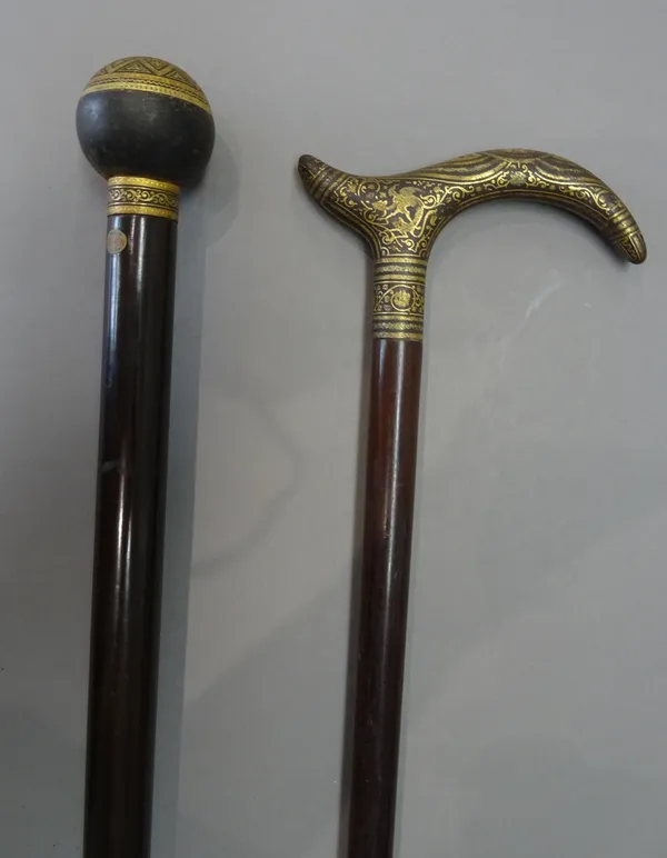 A Damascene gilt Toledo walking cane, early 20th century, with a spherical pommel and hardwood cylindrical shaft (92cm) and another Toledo walking sti