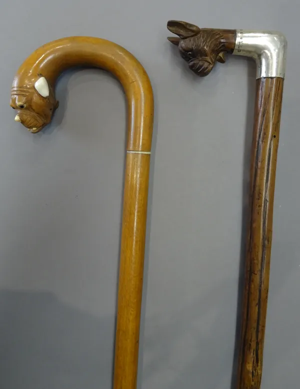 A Black Forest carved wooden 'dog's head' walking stick, circa 1910, with automated mouth and a hallmarked silver collar, London 1912, (75cm) and anot