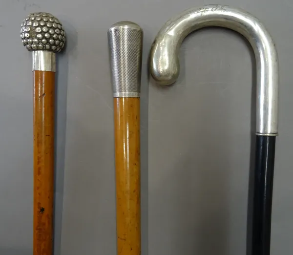 A silver topped malacca walking cane, engine turned and hallmarked London 1919 (88.5cm), a white metal topped malacca cane of spherical 'knobbly' form