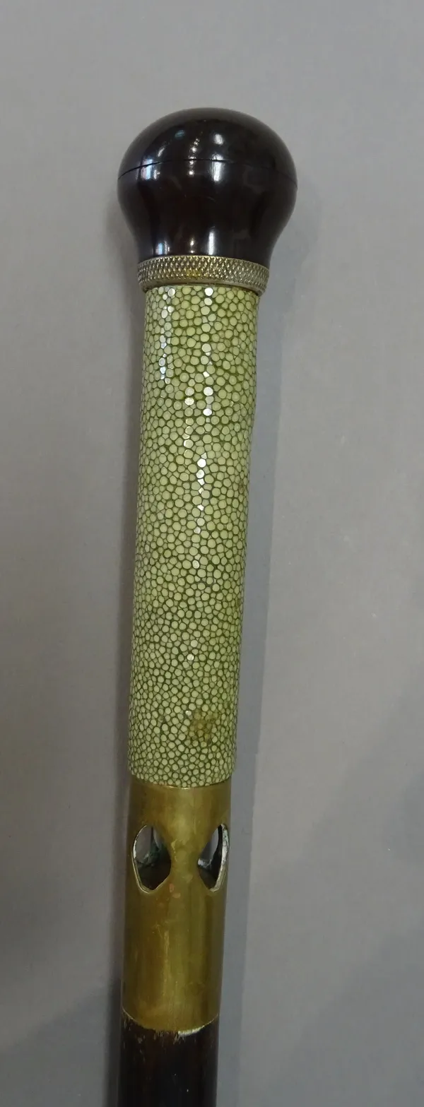 An Edwardian shagreen and ivory mounted 'torch' gadget cane with push button pommel and shagreen bound grip, over a pierced brass collar enclosing a t