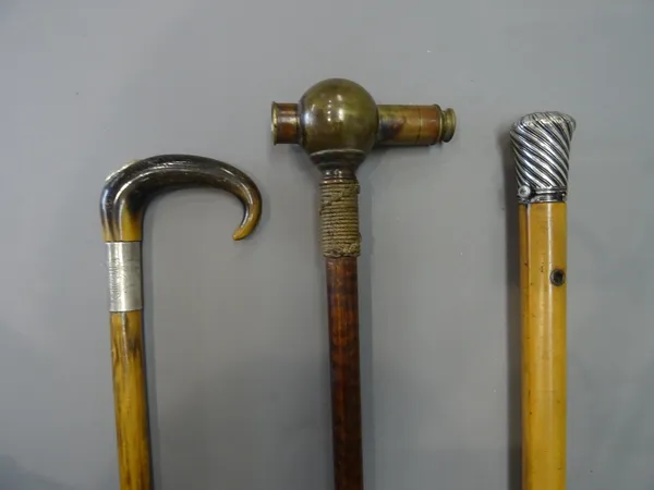 A Victorian brass 'telescope' gadget cane, with a rope bound collar and patterned shaft (93cm), a silver topped malacca cane enclosing a glass vial (9