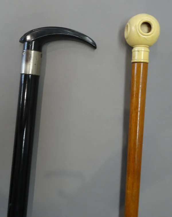 A Victorian ivory mounted 'Puzzle ball' walking cane (85.5cm) and an unusual ebonised gadget walking stick with torch light to the terminal (80cm), (2