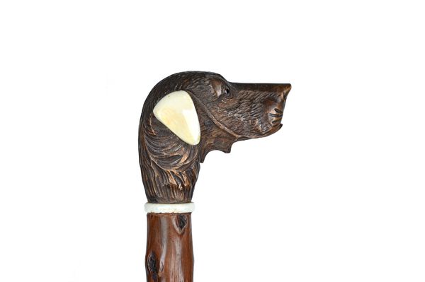 A Black Forest carved wood and ivory mounted novelty walking cane, late 19th century, the pommel as a dog's head with automated mouth and applied whit