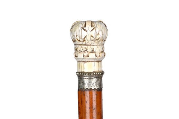 An ivory and malacca walking cane, the ivory pommel, late 17th century, carved as a crown over a white metal collar and malacca shaft, 81cm. Illustrat