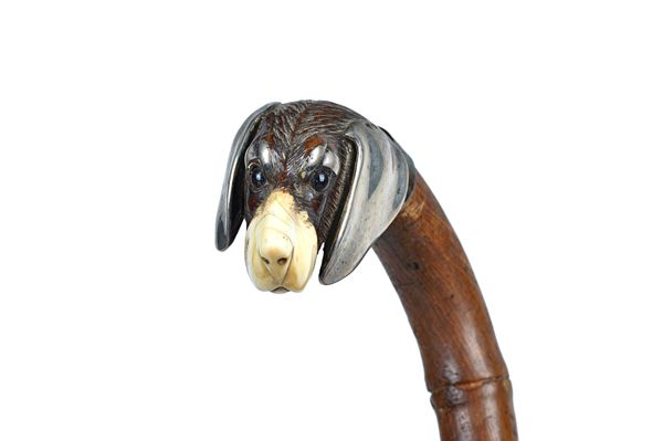 A Black Forest walking stick, circa 1900, with carved dog's head pommel, ivory nose/mouth and white metal mounts, on a bamboo shaft, 90cm. Illustrated