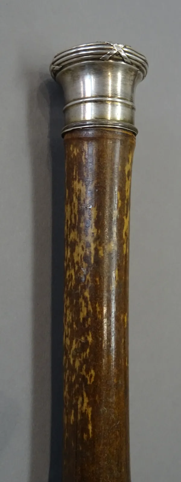 A white metal mounted bamboo gadget walking cane, late 19th century, the top enclosing a vial for water, the middle with an artists's paint palette an