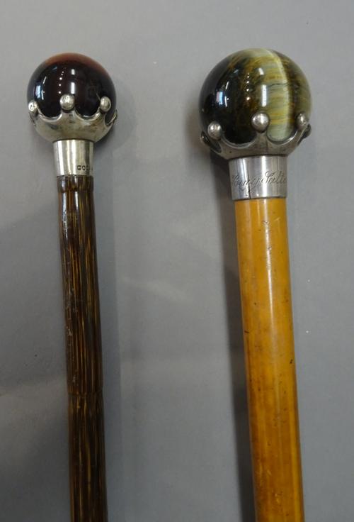 A hardstone and silver mounted walking cane with spherical 'tiger's eye' pommel and crown silver mount, hallmarked London 1889, (85cm) and another sim