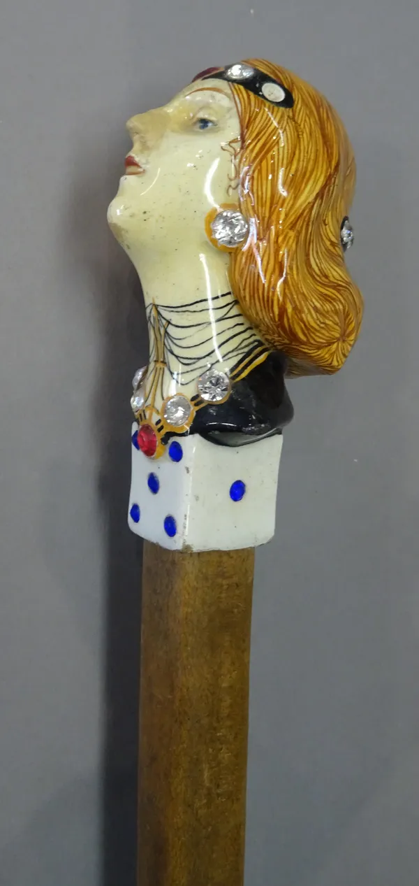 An Italian figural pottery walking stick pommel, 20th century, modelled with a bust of an Art Deco lady, above a die, over a tapering square wooden sh