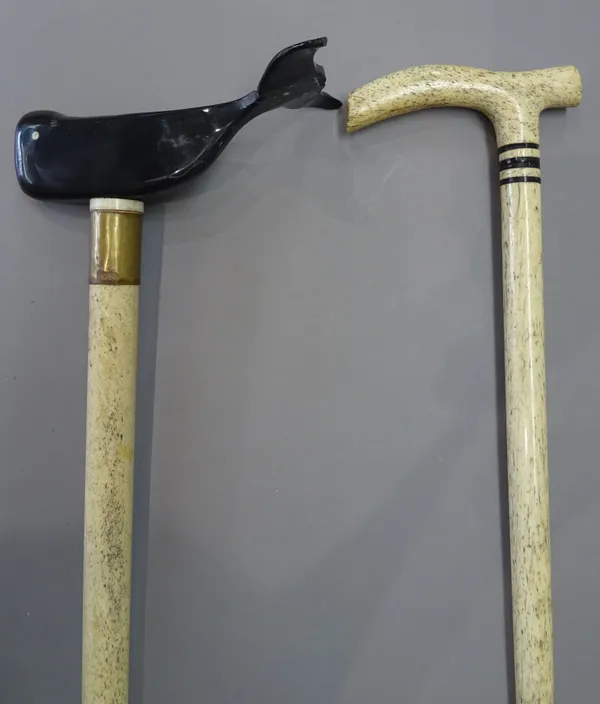 A horn and whalebone walking stick, 19th century, the handle carved as a whale, (93cm) and one further whalebone walking stick, (85cm), (2).