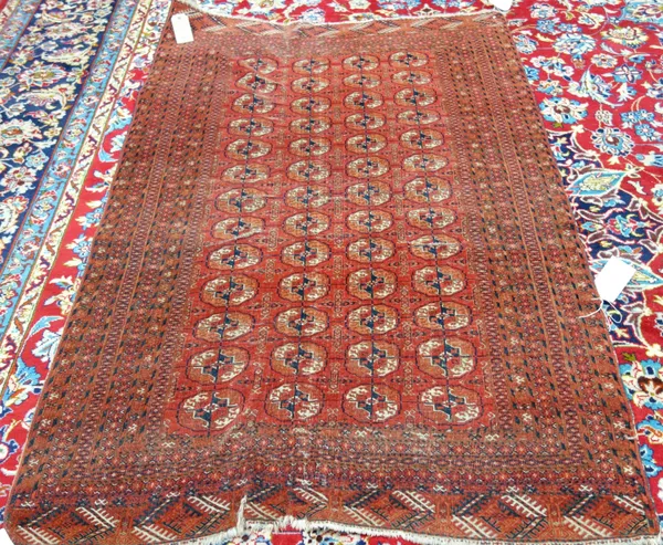 A Tekke Turkeman rug, early 20th century, the red ground with four rows of thirteen guls and subsidiary guls, in a striped border, 120cm x 174cm.