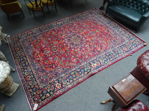 An Esfahan carpet, Persian, the madder field with a lobed indigo medallion, pale indigo spandrels, all with floral sprays, an indigo palmette and flor