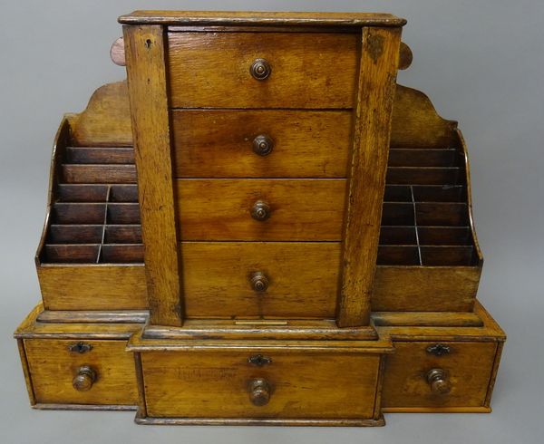'A. Webster & Stockley, 60, Piccadilly. W'; a Victorian oak table top desk tidy, the four central drawers with faux Wellington style locking bars, fla